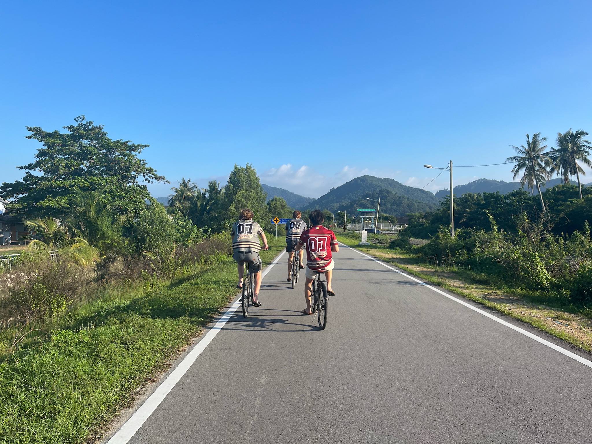Three cyclists on a road through Southeast Asia